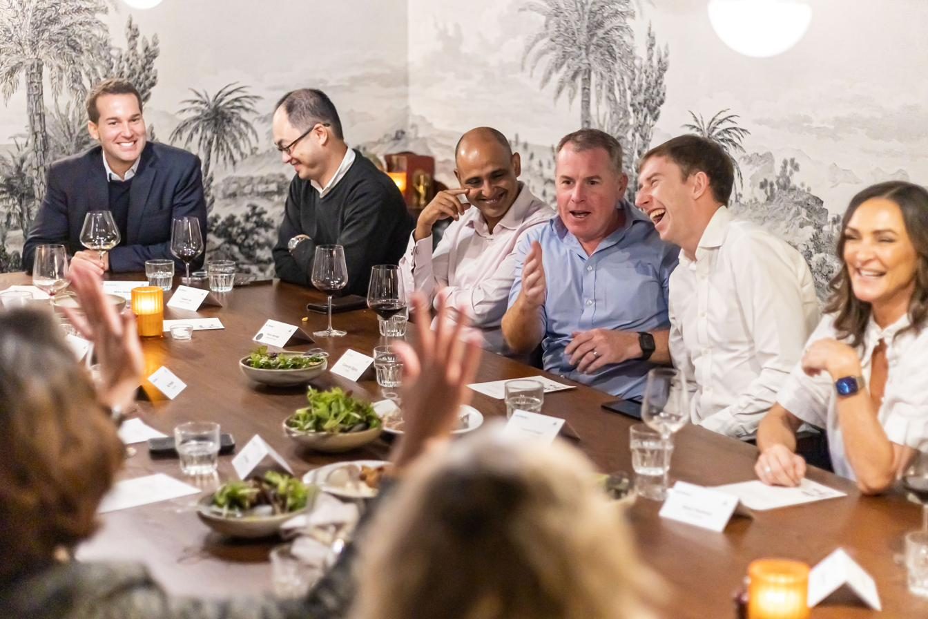 Senior leaders in conversation around a roundtable dinner